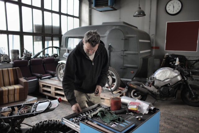 Bearded mechanic checking instruments while working in garage